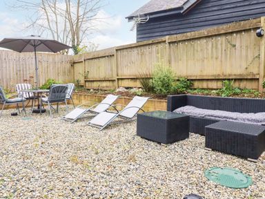 A garden area with seating and loungers at Meadow Retreat in Wadebridge