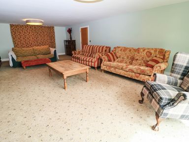 A living room with multiple sofas and a coffee table at Hazeldene near Harvington