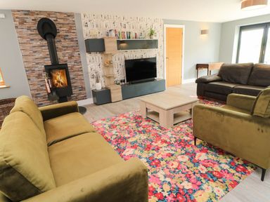 A living room with a fireplace and seating at Hazeldene near Harvington