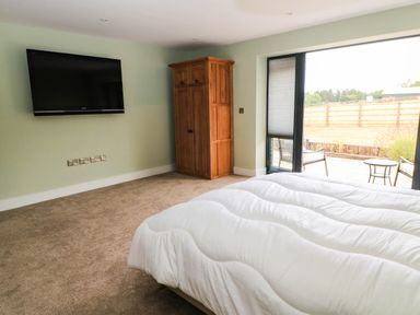 A bedroom with a bed and a wardrobe at Hazeldene near Harvington