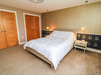 A bedroom with a bed and nightstand at Hazeldene near Harvington