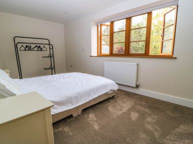 A bedroom with a bed and clothes rack at Hazeldene near Harvington