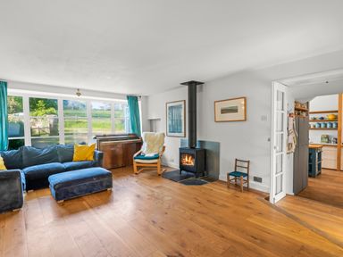 A living room with a sofa and stove at Chantry Studio in Kingsbridge