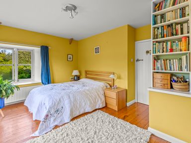 A bedroom with a bed and bookshelf at Chantry Studio in Kingsbridge