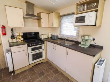 A kitchen with appliances and cabinets at Sunflower Retreat, Caravan 61