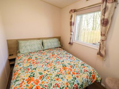 A bedroom with a bed and window at Sunflower Retreat, Caravan 61