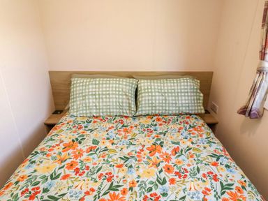 A bedroom with a bed and green checkered pillows at Sunflower Retreat, Caravan 61