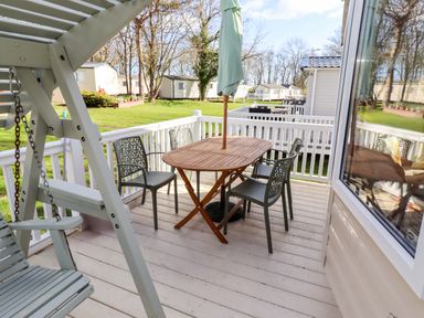 An outdoor seating area with a table and chairs at Sunflower Retreat, Caravan 61