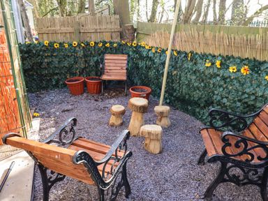 A garden area with wooden furniture and flower pots at Sunflower Retreat, Caravan 61