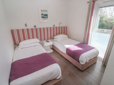 A bedroom with two beds and a window at Warleggan in Redruth