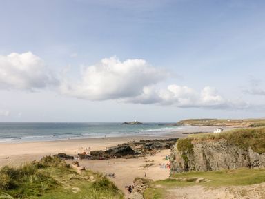 A beach with people and rocks at Warleggan in Portreath