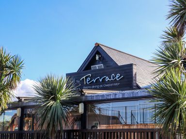 The exterior of The Terrace with palm trees at Gwelan Mor in Portreath