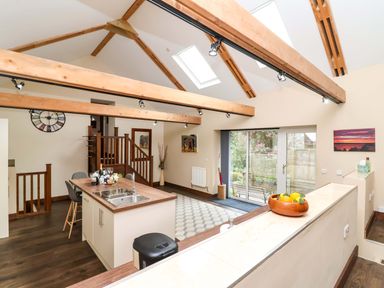 A kitchen with an open layout and island at Cider Press Cottage in Torpoint