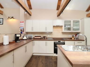 A kitchen with cabinets and appliances at Cider Press Cottage Torpoint