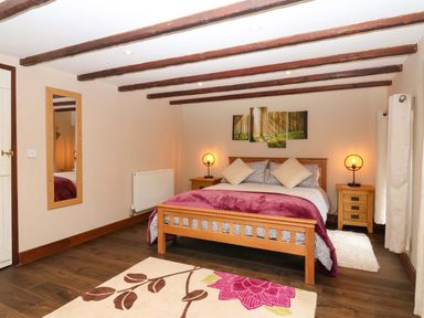 A bedroom with a bed and bedside tables at Cider Press Cottage in Torpoint