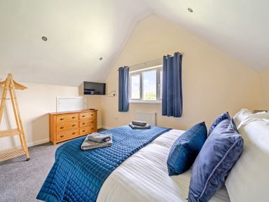 A bedroom with a bed and dresser at Lodge 4 Near Brigg