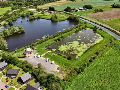 An aerial view of a pond surrounded by grass and buildings at Lodge 4 near Brigg