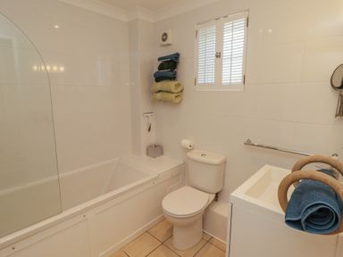 A bathroom with a bathtub toilet sink and towels at The Bolthole in Newport