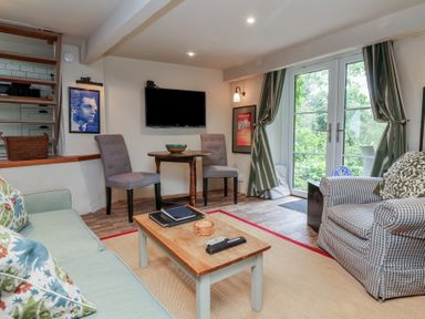 A living room with a sofa and chairs at The Bothy at Lewis Cottage in Spreyton