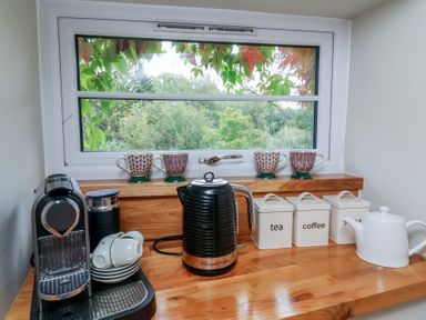 A kitchen counter with a kettle and coffee maker at The Bothy at Lewis Cottage, Spreyton