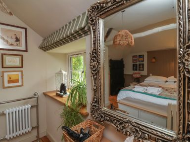 A bedroom showing a mirror and a bed at The Bothy at Lewis Cottage Spreyton