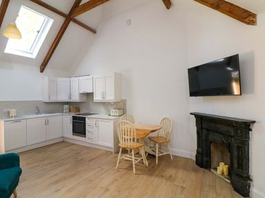 A kitchen with cabinets, stove, sink, table and chairs at The Mews @ Derrybawn, Laragh, County Wicklow