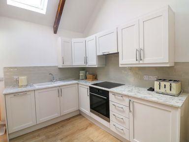 A kitchen with a sink, oven, and cabinets at The Mews @ Derrybawn, Laragh, County Wicklow