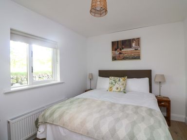 A bedroom with a bed and window at The Mews @ Derrybawn, Laragh, County Wicklow
