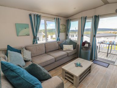 A living room with a sofa and coffee table at Swanny View in Swanage