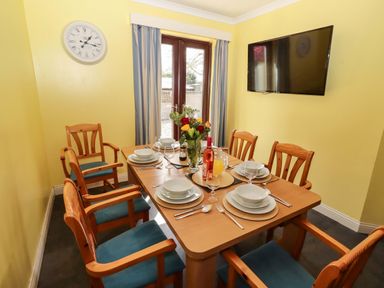 A dining room with a table set for dining at Willow cottage in Seahouses
