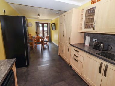 A kitchen with a dining table and chairs at Willow cottage in Seahouses