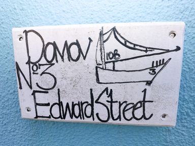 A nameplate displaying a boat drawing and address at 3 Edward Street, Tenby