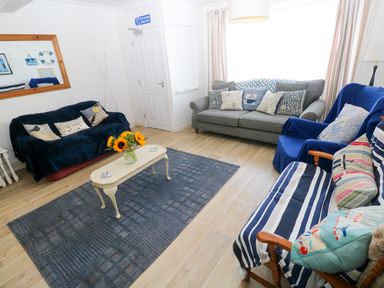 A living room with a sofa and a coffee table at 3 Edward Street in Tenby