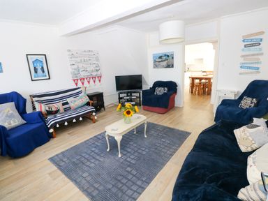 A living room with a television and seating area at 3 Edward Street in Tenby