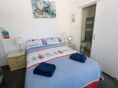 A bedroom with a bed and bedside table at 3 Edward Street Tenby