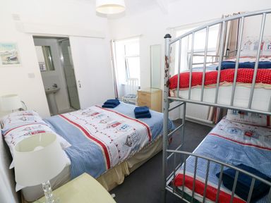 A bedroom with a double bed and bunk bed at 3 Edward Street Tenby
