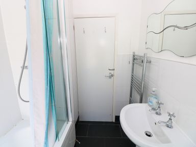 A bathroom with a bathtub and shower at 3 Edward Street Tenby