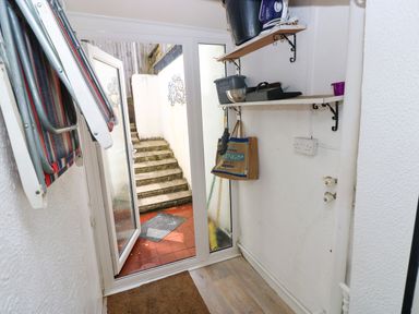 A hallway with stairs leading outside at 3 Edward Street Tenby