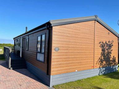 An exterior view of a lodge with a deck area at Yorkshire View Lodge in Wilberfoss