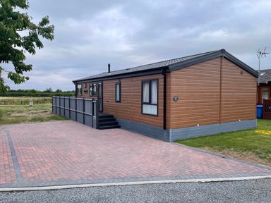 A house with decking and a driveway at Yorkshire view lodge in Wilberfoss