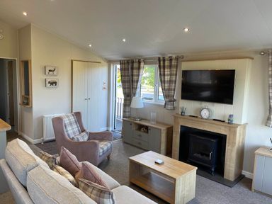 A living room with a sofa, chair, and television at Yorkshire view lodge in Wilberfoss