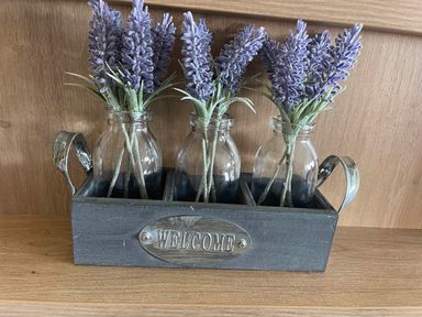 A flower arrangement in bottles with a welcome sign at Yorkshire view lodge Wilberfoss