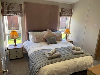 A bedroom with a double bed and bedside tables at Yorkshire View Lodge in Wilberfoss