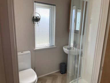 A bathroom with a toilet, shower, and sink at Yorkshire view lodge Wilberfoss