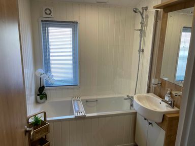 A bathroom with a bath tub, sink, and shower at Yorkshire view lodge Wilberfoss