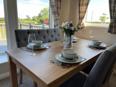 A dining room with a table set for three at Yorkshire view lodge in Wilberfoss