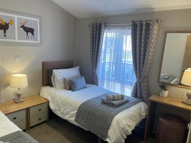 A bedroom with twin beds and a lamp at Yorkshire view lodge in Wilberfoss