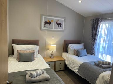 A bedroom with two single beds and a nightstand at Yorkshire view lodge in Wilberfoss