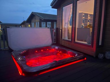 A hot tub on a deck outside a building at Yorkshire view lodge in Wilberfoss