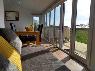 A dining area with a table and chairs at Cleeves Cabins 2, Arran Luxury Lodge with hot tub St. John's Town Of Dalry